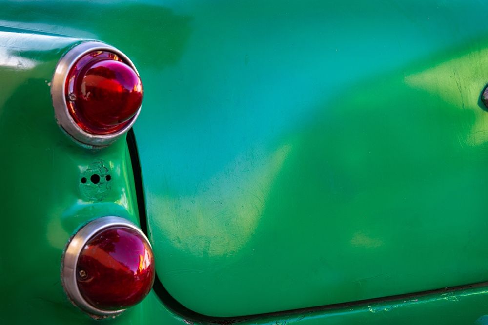 Detail of two red tail lights on classic green car in Trinidad-Cuba